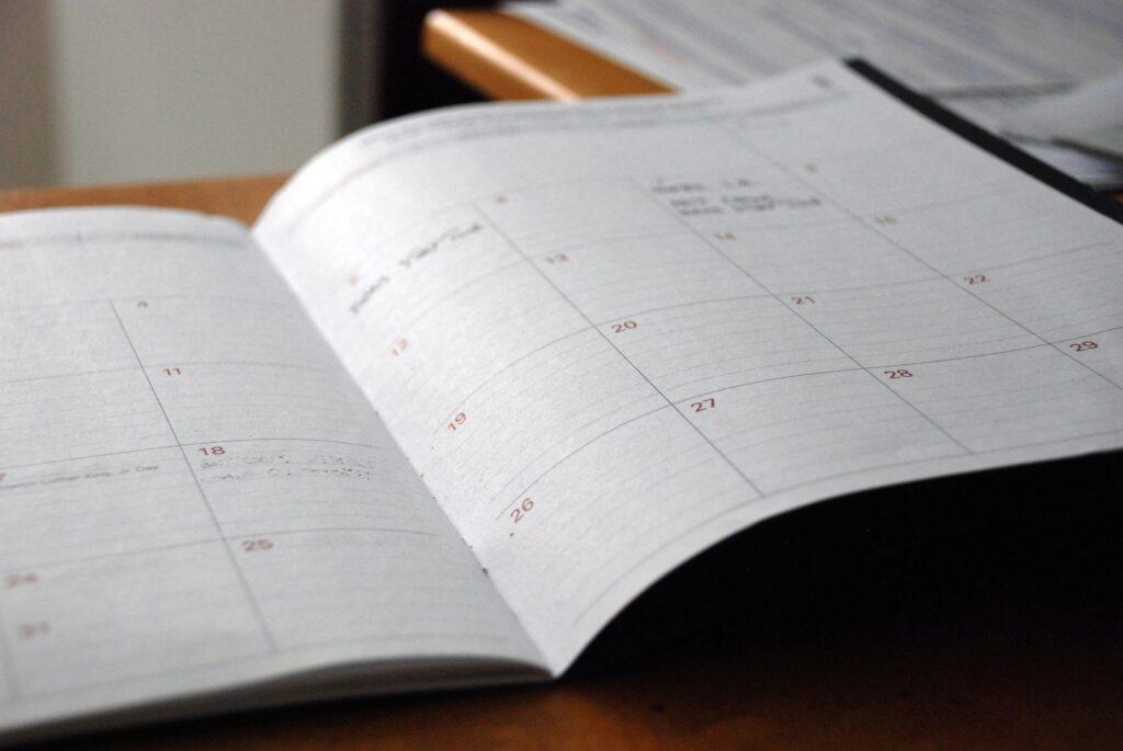 Agenda mensual abierta sobre un escritorio de madera