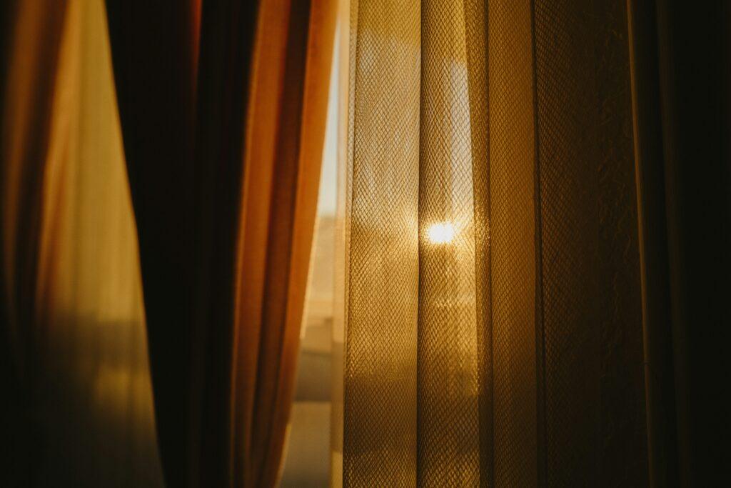 Luz del sol entrando por las cortinas de una ventana